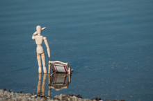 Closeup Of Wooden Mannequin In Wooden Lounge Chair In The Water