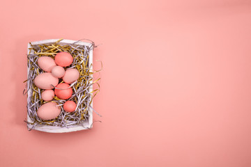 Wall Mural - Eggs in a white tray. Creative Easter concept. Modern solid pink background. Living coral accent, color of the year 2019