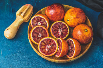 Wall Mural - Sliced and whole Sicilian Blood oranges fruits in wooden plate