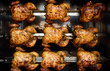 Rows of Hot Roasted Skewered Whole Rotisserie Chickens In Colombia, South America