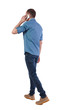 © ghoststone - Back view of man walking with a mobile phone.