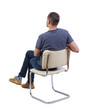 © ghoststone - Back view of a man sitting on a chair.