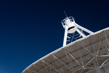 Wall Mural - very large array radio telescope pointing into space, white dish against a deep blue sky, space tech
