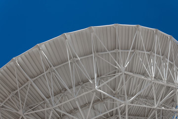 Wall Mural - very large array sweeping arch showing understructure of a large dish telescope against a blue sky, 