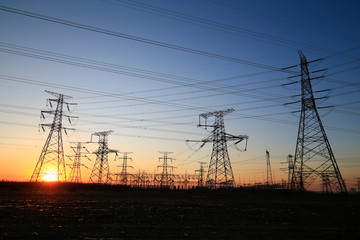 Wall Mural - A high-voltage tower in the setting sun against the sky