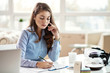 © Drazen - Young businesswoman filing paperwork at her office desk.