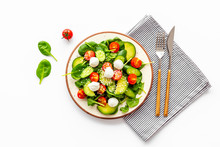 Fresh Salad With Mozzarella, Spinach, Cherry Tomatoes, Cucumber On Plate On White Background Top View Copy Space