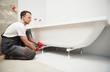© Kadmy - bathtube installation. plumber installing and mounting bath