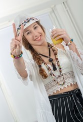 Wall Mural - pretty young woman with a summer hat drinks glass of orange juic