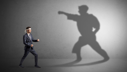 Wall Mural - Young karate man confronting with his own shadow
