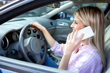 Wall Mural - Holding the mobile phone with one hand and wheel with the other