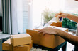 © wutzkoh - Asian young teenager owener of small business packing product in boxes preparing it for delivery.