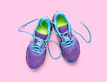 Top View Of Blue And Purple Trainers Isolated On A Pink Background.