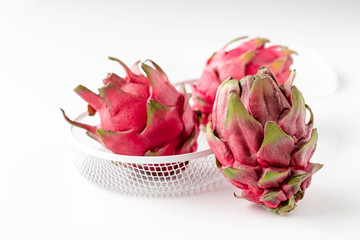 Wall Mural - Fresh organic red dragon fruits on a white background, creative healthy food concept