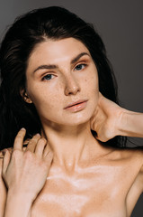 Wall Mural - naked tender girl with freckles on face isolated on grey