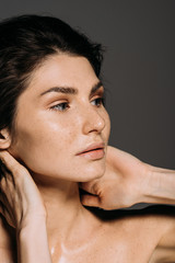 beautiful young woman with freckles on face isolated on grey