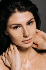 attractive woman with freckles on face isolated on grey