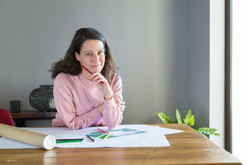 Smiling pensive interior designer thinking over renovation plan