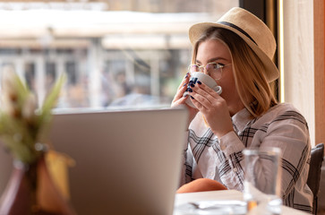 Young woman sitting at the cafe and enjoying cup of coffee.