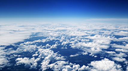 Wall Mural - flying over picturesque white clouds on the deep blue sky. beautiful moving clouds view from airplan