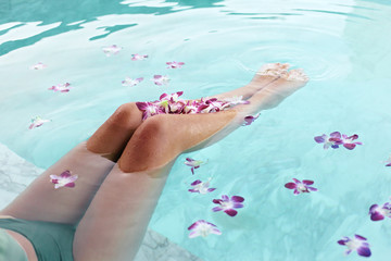 Girl relaxing in tropical spa pool with flowers