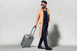 © ASjack - Elegant young handsome man with luggage. Studio fashion portrait.