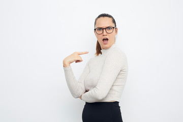 portrait of a young surprised woman pointing