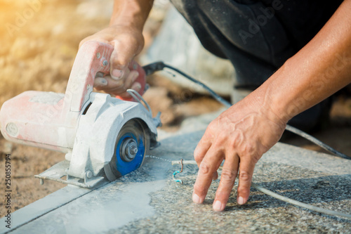 Cuadros en Lienzo worker cutting granite stone with an diamond electric saw blade and use water to