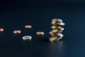 Coins stacked on each other in different positions on a black background