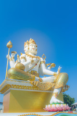 Giant white Brahma statue with blue sky background. Brahma is the Hindu Creator god. He is also known as the Grandfather and supreme in the triad of great Hindu gods which includes Shiva and Vishnu.