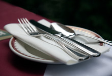 Close Up Of Silverware And Cloth Napkin On Fine China