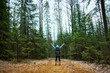 © Cavan Images - Female hiker standing in forest with arms raised