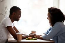 Happy Multiracial Couple Holding Hands, Enjoying Date In Cafe