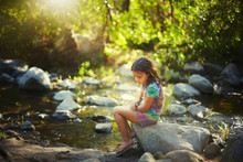 Girl Sitting On Stone Near River 