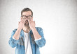 © ImageFlow - Casual man covering eyes with hands, concrete
