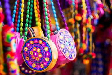 Colorful, textile, hand made hand bags hanging in a shop in Gujarat 