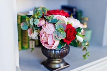 Wall Mural - Flowers in an old vase on the shelf with books