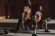 © alfa27 - Focused male african and caucasian athletes showing determination and endurance exercising legs and back musculs during body core crossfit workout
