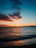 Fototapeta Most - Sun setting on beautiful empty beach - Kavala, Greece
