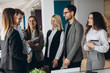 © JJ Studio - Beautiful business people are using gadgets, talking and smiling during the conference in office