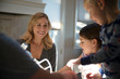 © Cavan Images - Children (6-7, 8-9) with parents preparing food in kitchen