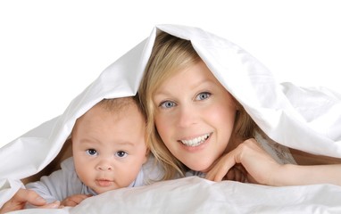 Wall Mural - mother and little baby boy under bed sheets in the bedroom stock image with white background stock photo