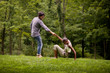 © Cavan Images - Young man helping girlfriend up from grass