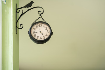 Black clock hanging at the wall.