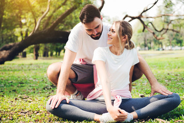 Wall Mural - Young couple stretching at the park