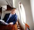 © Cavan Images - Man reading newspaper on private jet
