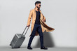 © ASjack - Elegant young handsome man with luggage. Studio fashion portrait.