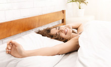 Smiling Woman Waking Up In Her Bed