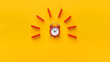 Alarm Clock With Red Dominoes On Yellow Background