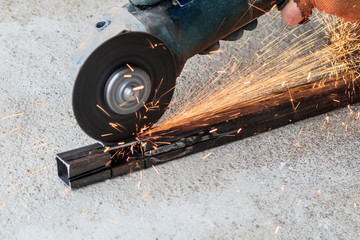 master using grinders. a lot of sparks burn and work. cuts a square pipe. have toning. close-up